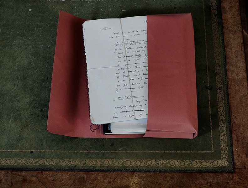 An open card folder full of hand written notes on a desk